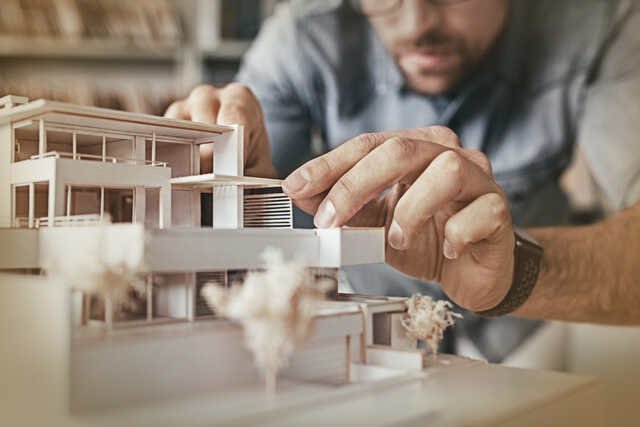 Ein Mann baut ein Modell von einem Haus