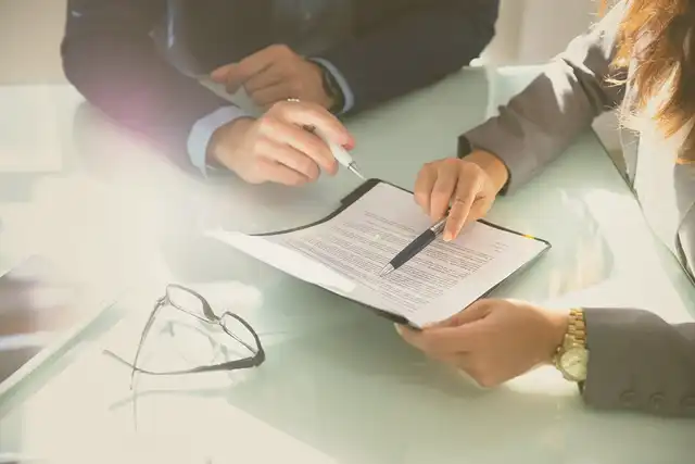 Hände die einen Vertrag gemeinsam überprüfen 