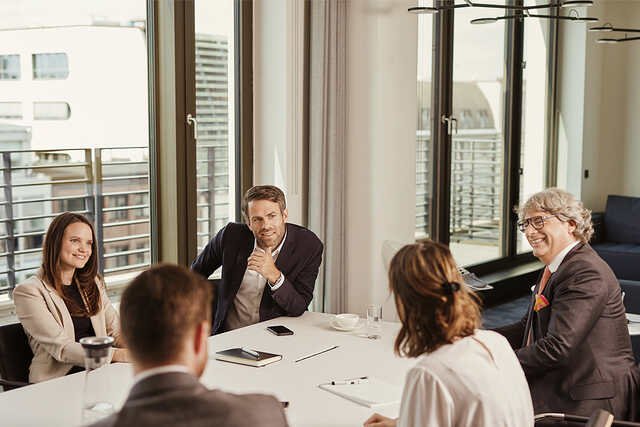 Mehrere Mitarbeiter haben eine Konferenz an einem Tisch 