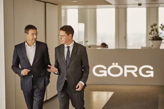 Anwälte die eine Unterhaltung vor der GÖRG Empfangstheke haben 