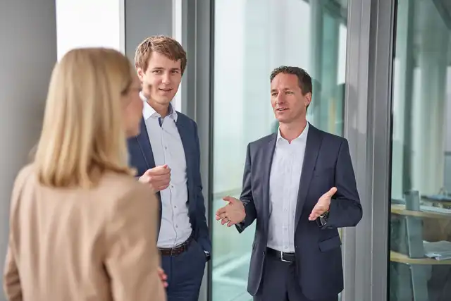 Ein Mann erklärt zwei Personen etwas