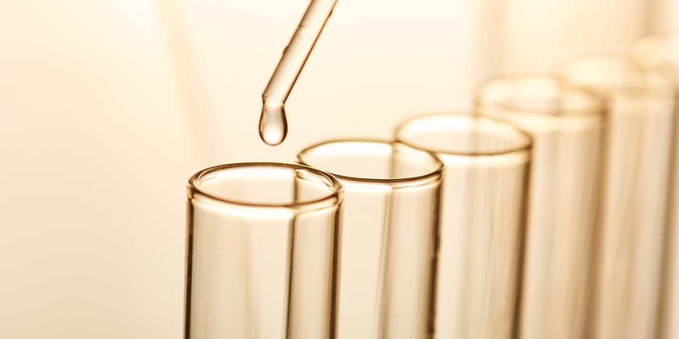 Eine Pipette die Flüssigkeit in Reagenzgläser gibt 