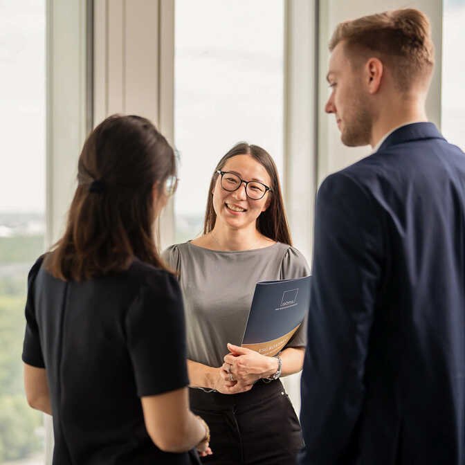 Eine Anwältin im Gespräch mit zwei Kolleg:innen