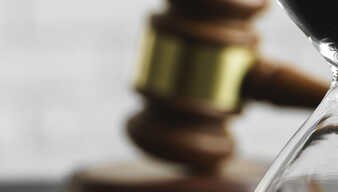 Sanduhr und Rechtssymbol in Form eines Hammers