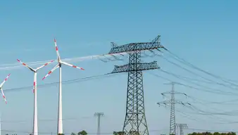 Stromnetzwerk, Solarpanele und Windräder auf Wiese